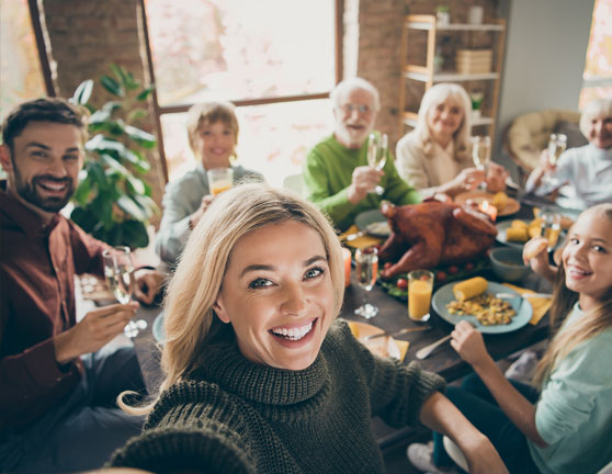 Familia durante una comida sacándose una foto mientras celebran
