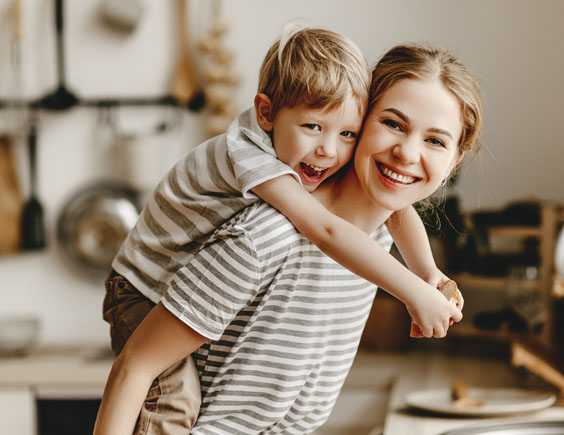Madre llevando a su hijo sobre su espalda