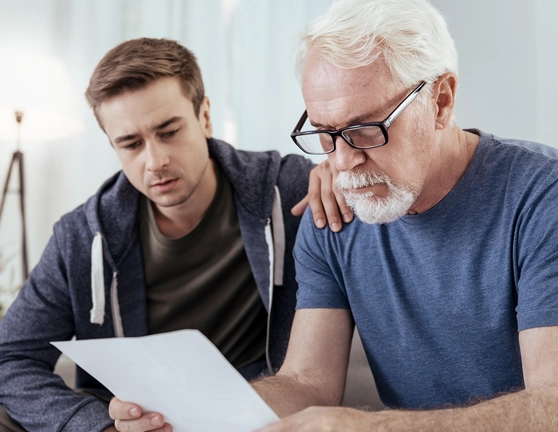 Dos hombres revisando un documento concentrados y con cara de preocupación